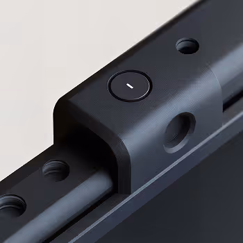 Close-up of a black metal component featuring a circular button with a white dash symbol.