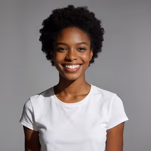 Smiling young woman with short curly hair wearing a white t-shirt on a gray background.